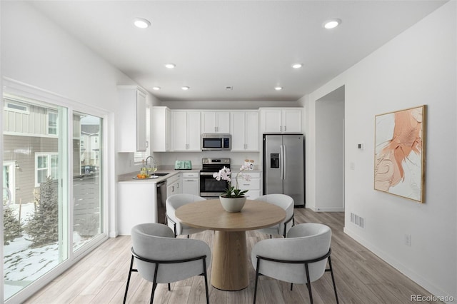 dining area featuring sink and light hardwood / wood-style flooring