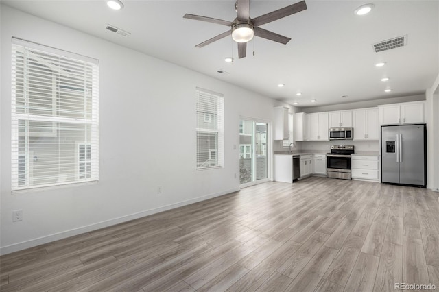 kitchen with white cabinetry, light hardwood / wood-style floors, ceiling fan, and appliances with stainless steel finishes