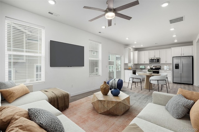 living room with ceiling fan and light wood-type flooring