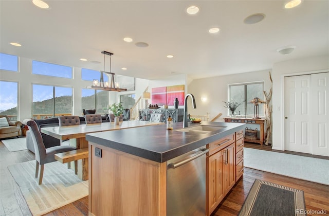 kitchen with a sink, a wealth of natural light, open floor plan, and dishwasher