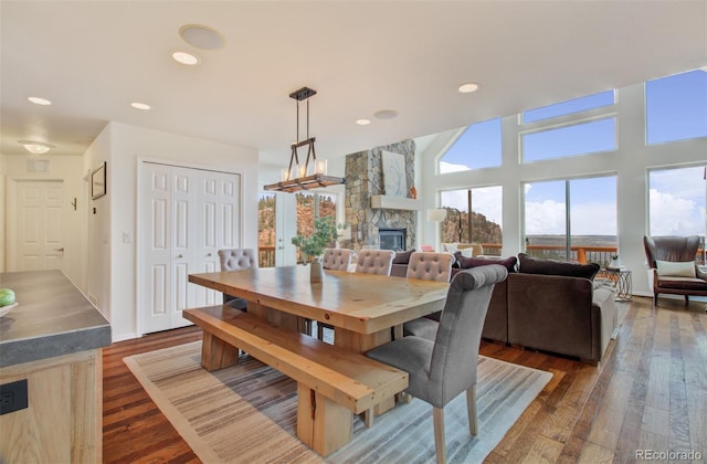 dining area featuring dark wood finished floors, a fireplace, and recessed lighting