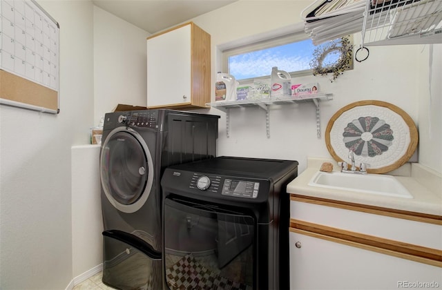 washroom featuring cabinet space, washer and dryer, and a sink