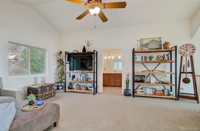sitting room with lofted ceiling, carpet flooring, and a ceiling fan