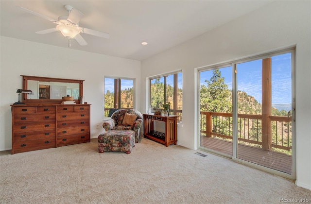 sitting room with carpet floors, a ceiling fan, and visible vents