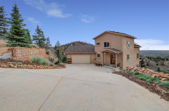 traditional home featuring driveway, stucco siding, and a garage