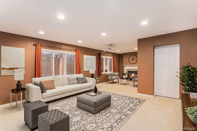 living room with a glass covered fireplace, light carpet, baseboards, and recessed lighting