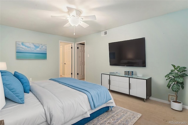 bedroom with light carpet, ceiling fan, visible vents, and baseboards