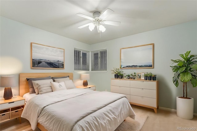 bedroom with ceiling fan, light carpet, and baseboards