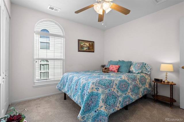 carpeted bedroom with multiple windows, visible vents, and ceiling fan