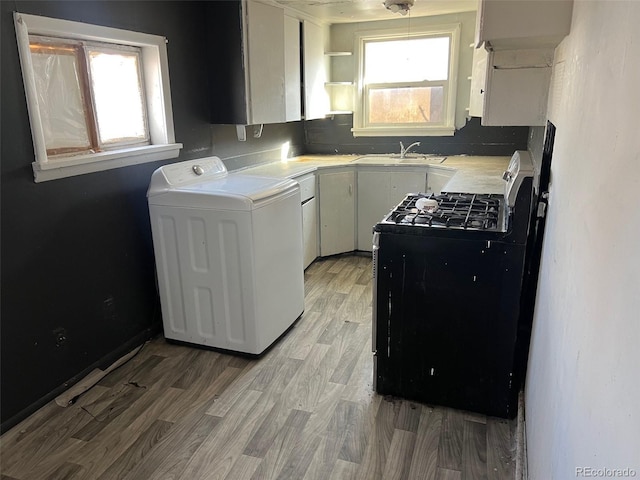 kitchen with washer / clothes dryer, white cabinetry, plenty of natural light, and range with gas stovetop