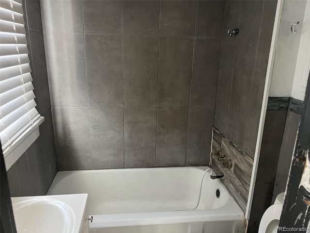 full bathroom with tiled shower / bath combo, vanity, and toilet