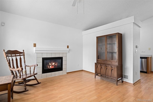 8761 Cloverleaf Cir, Parker, CO 80134 - living area featuring light wood-style flooring, a ceiling fan, and a fireplace