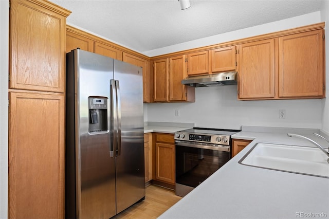 8761 Cloverleaf Cir, Parker, CO 80134 - kitchen with stainless steel appliances, under cabinet range hood, light countertops, and light wood-style flooring
