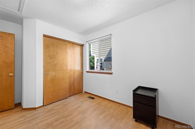 8761 Cloverleaf Cir, Parker, CO 80134 - unfurnished bedroom featuring a textured ceiling, light wood-style floors, and a closet