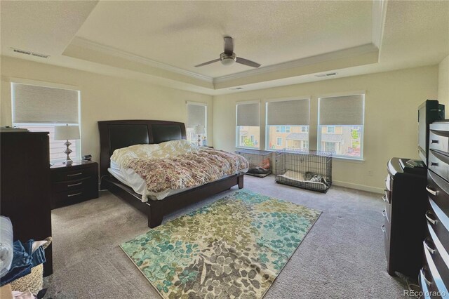 bedroom featuring ceiling fan, a raised ceiling, and light carpet