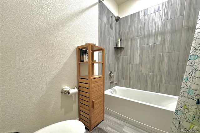 bathroom featuring shower / bathtub combination with curtain and toilet