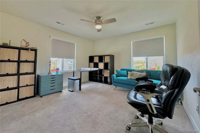 carpeted home office featuring ceiling fan