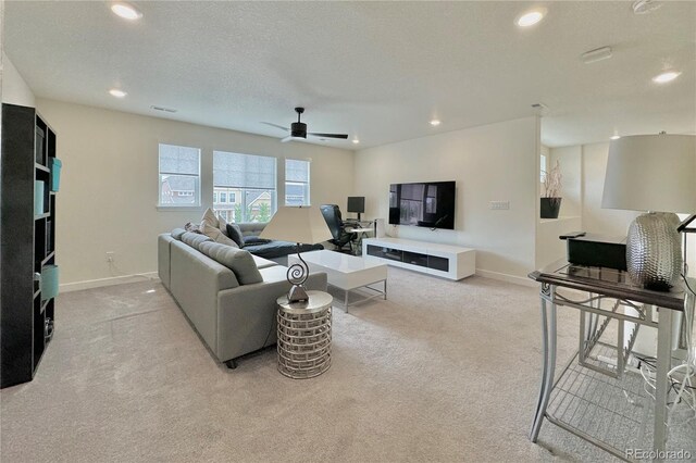 living room with a textured ceiling, ceiling fan, and light carpet