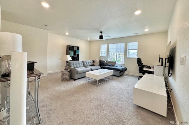 carpeted living room with a textured ceiling and ceiling fan