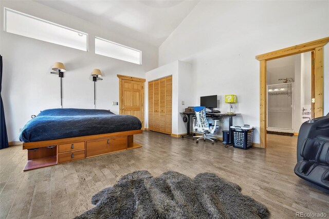 320 Summit Rd, Woodland Park, CO 80863 - bedroom featuring wood finished floors, high vaulted ceiling, a closet, a desk, and baseboards