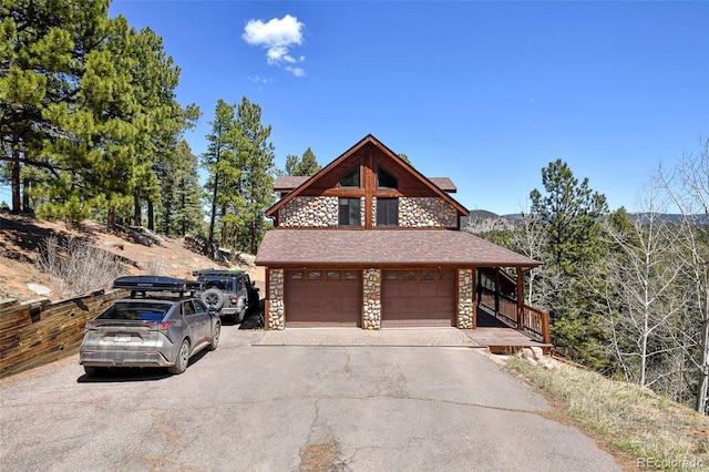 320 Summit Rd, Woodland Park, CO 80863 - view of side of property with stone siding, an attached garage, and driveway