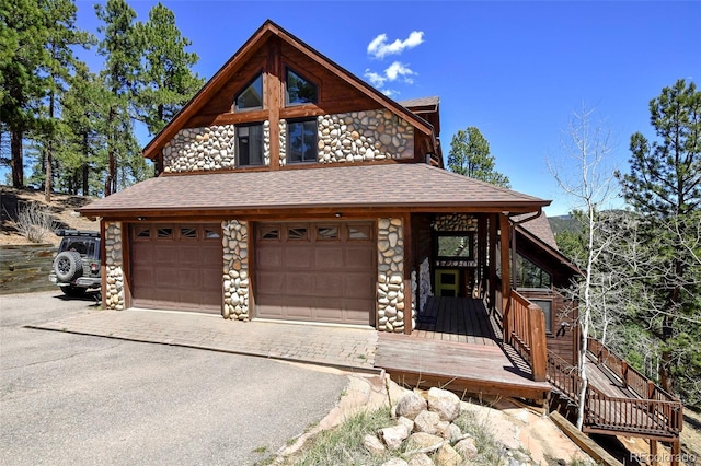 320 Summit Rd, Woodland Park, CO 80863 - view of front of property with stone siding, a shingled roof, and asphalt driveway