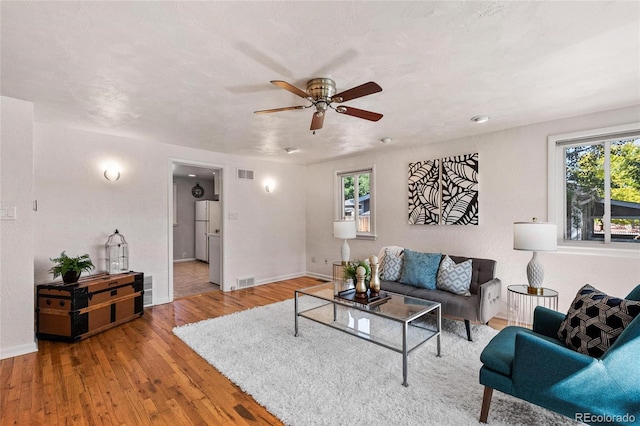 living room featuring hardwood / wood-style floors and ceiling fan