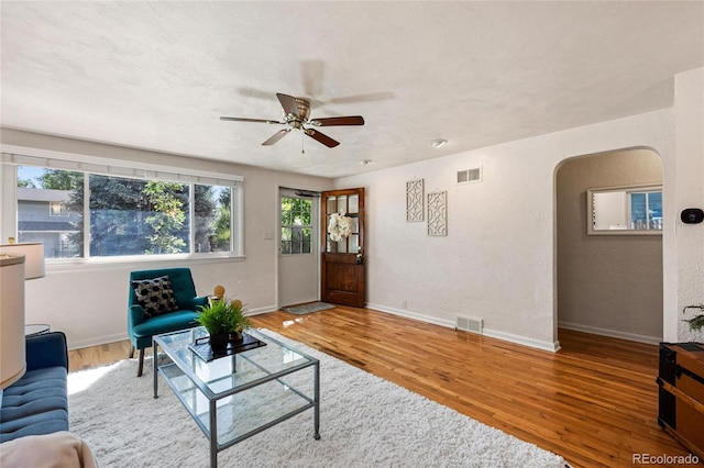 living room featuring hardwood / wood-style floors and ceiling fan