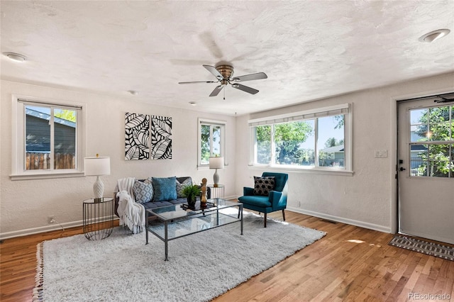 living room with a healthy amount of sunlight, ceiling fan, and hardwood / wood-style floors