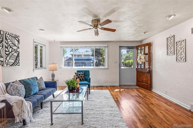 living room with a wealth of natural light, hardwood / wood-style floors, and ceiling fan