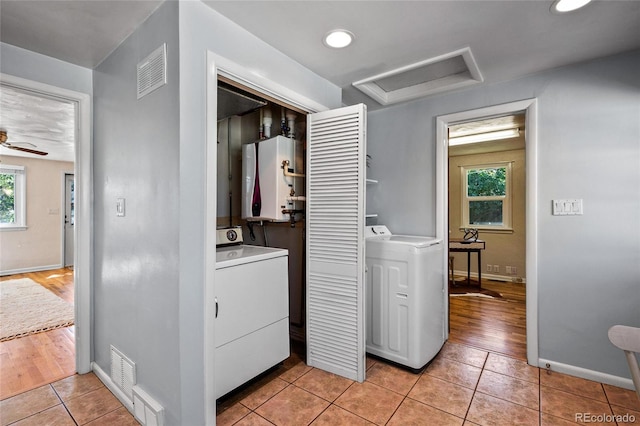 clothes washing area featuring washer / clothes dryer, a wealth of natural light, and light tile patterned floors