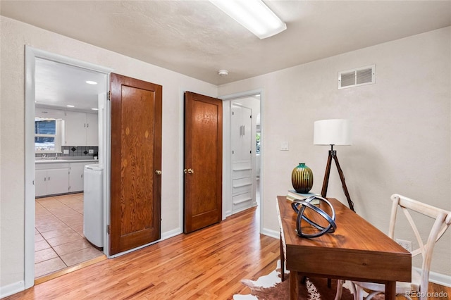 office space featuring light wood-type flooring and sink