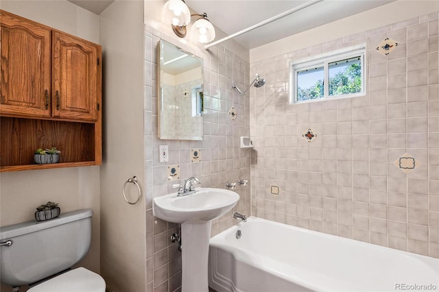 bathroom with toilet and tiled shower / bath combo