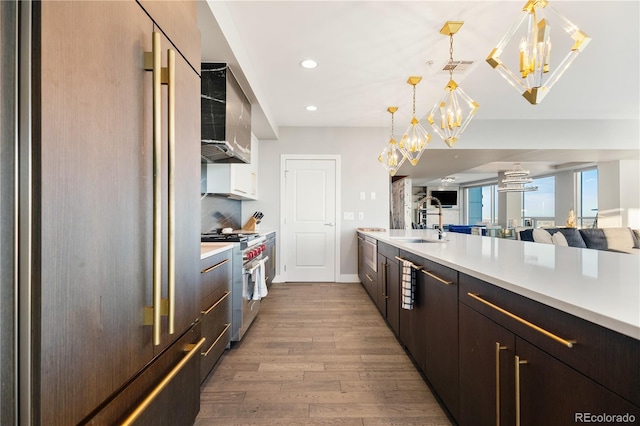 kitchen featuring wood finished floors, high quality appliances, open floor plan, light countertops, and pendant lighting