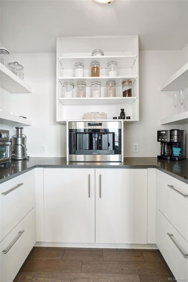 kitchen with open shelves, dark countertops, and white cabinetry