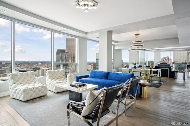 living room featuring a view of city, a tray ceiling, wood finished floors, and a chandelier