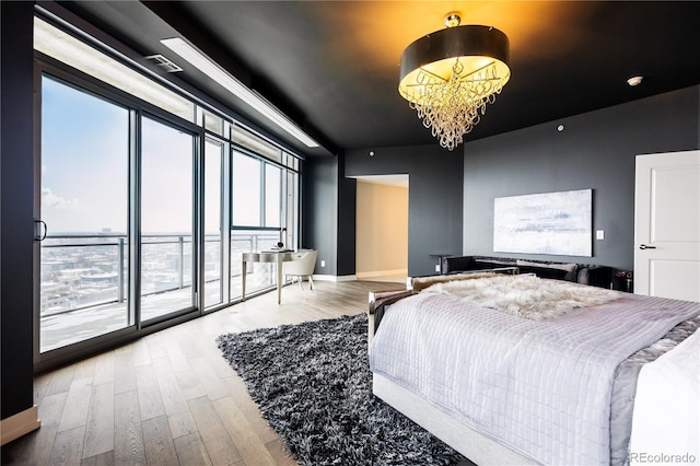 bedroom featuring baseboards, an inviting chandelier, light wood-style flooring, and access to exterior