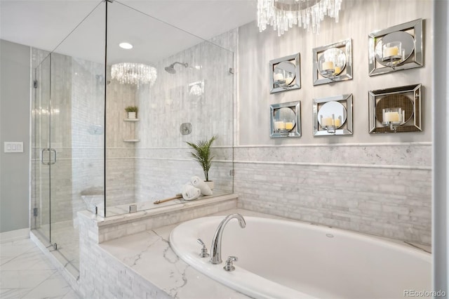 full bath with marble finish floor, a shower stall, a bath, and an inviting chandelier