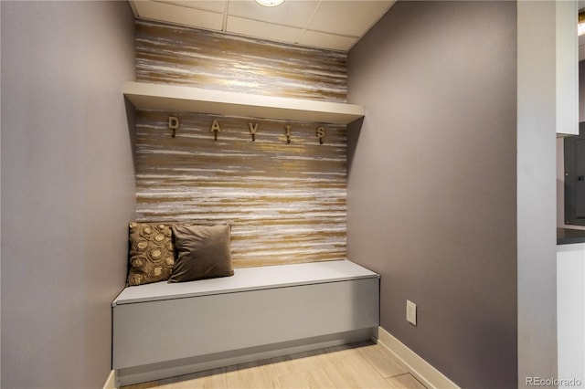 mudroom with light wood-style floors, a paneled ceiling, and baseboards