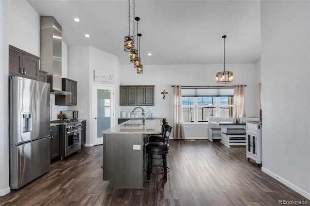 kitchen with a center island with sink, stainless steel appliances, tasteful backsplash, and sink