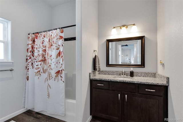 bathroom with shower / bathtub combination with curtain, hardwood / wood-style floors, and vanity