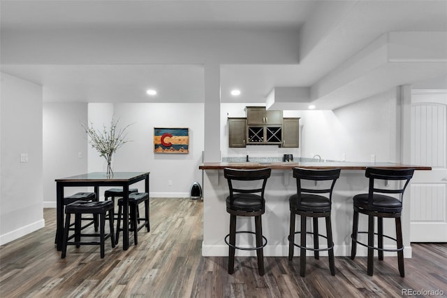 kitchen with a kitchen bar and dark wood-type flooring