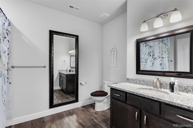 bathroom with toilet, hardwood / wood-style flooring, and vanity