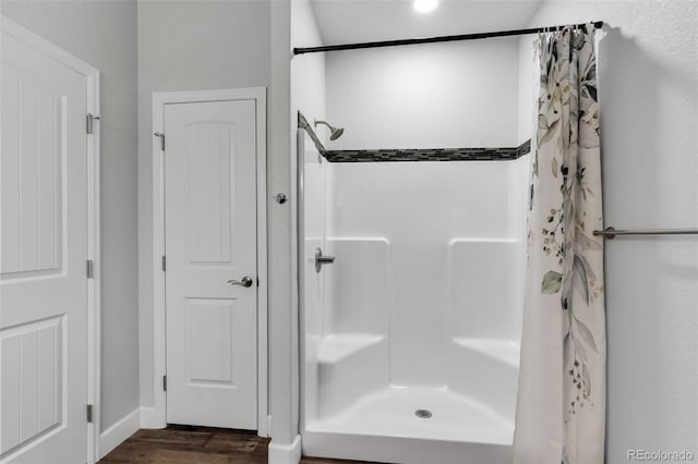 bathroom with hardwood / wood-style flooring and curtained shower