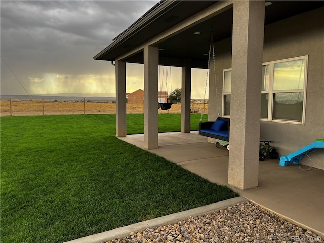 yard at dusk featuring a patio