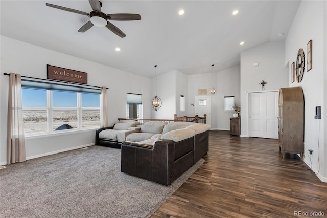 living room with ceiling fan with notable chandelier, dark wood-type flooring, and high vaulted ceiling