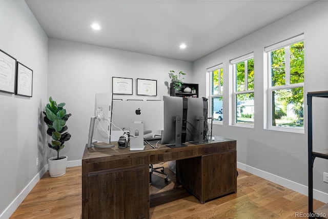 home office with light hardwood / wood-style flooring