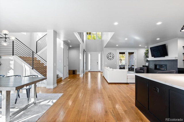 kitchen with light hardwood / wood-style flooring, a notable chandelier, and a brick fireplace