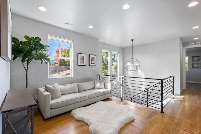 living room featuring wood-type flooring and a notable chandelier