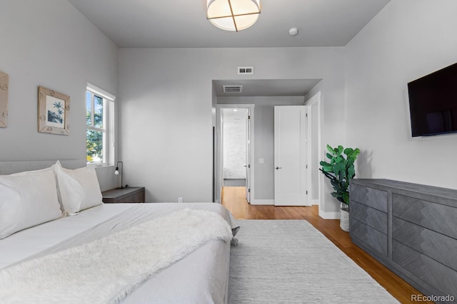 bedroom featuring hardwood / wood-style floors and ensuite bathroom